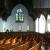 High ceilings and beautiful woodwork, with angled ampetheater pews.